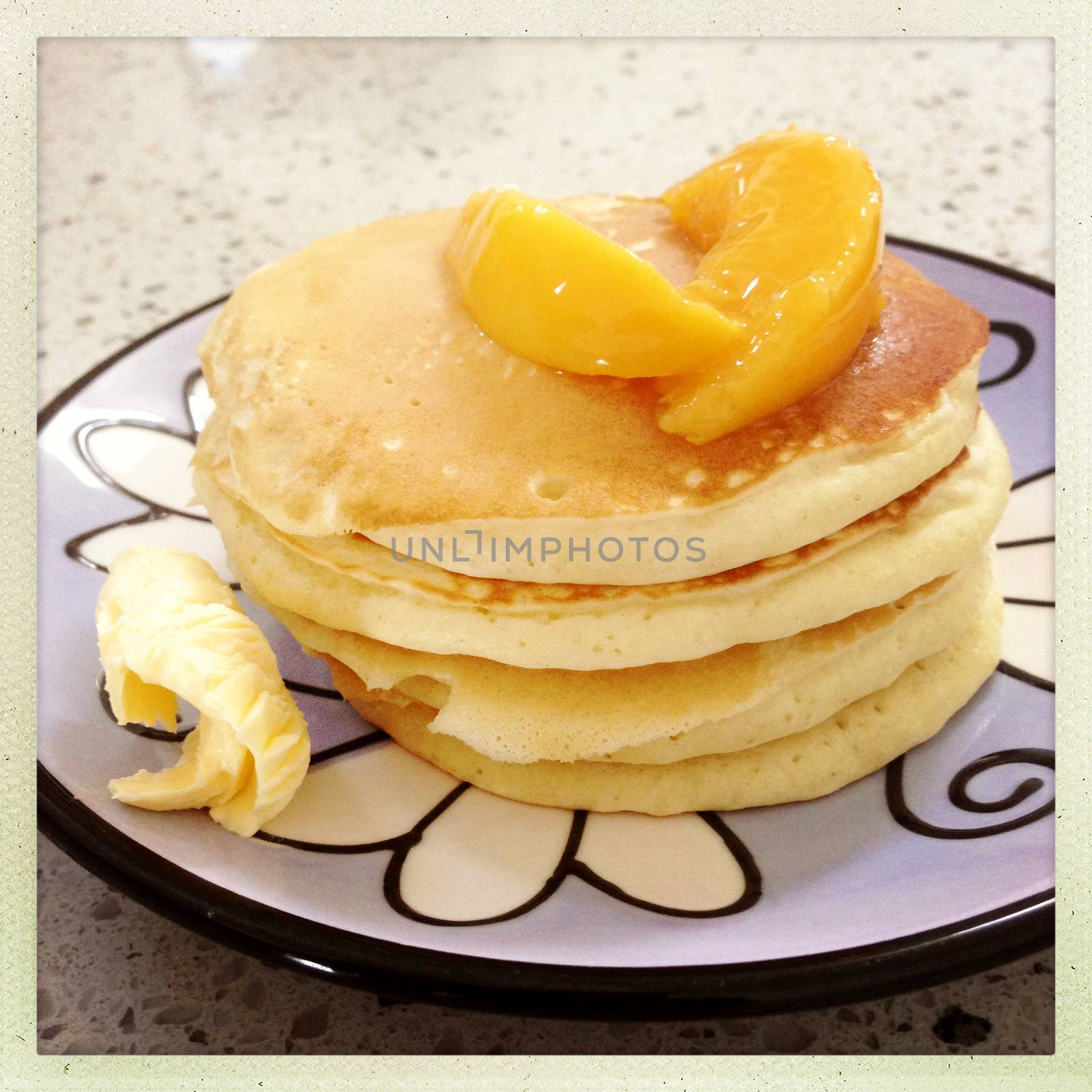 Stack of pancakes, peaches and butter