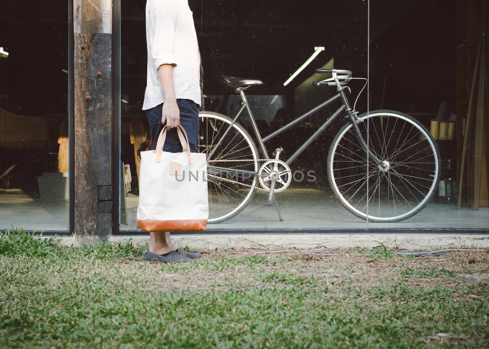 Man with canvas bag and vintage bicycle on background, Retro filter