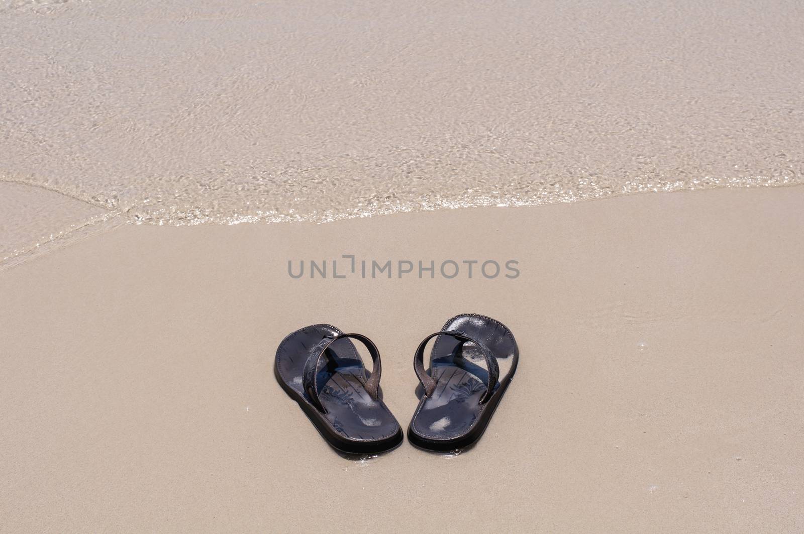 Beach sandals on a sandy beach with background
