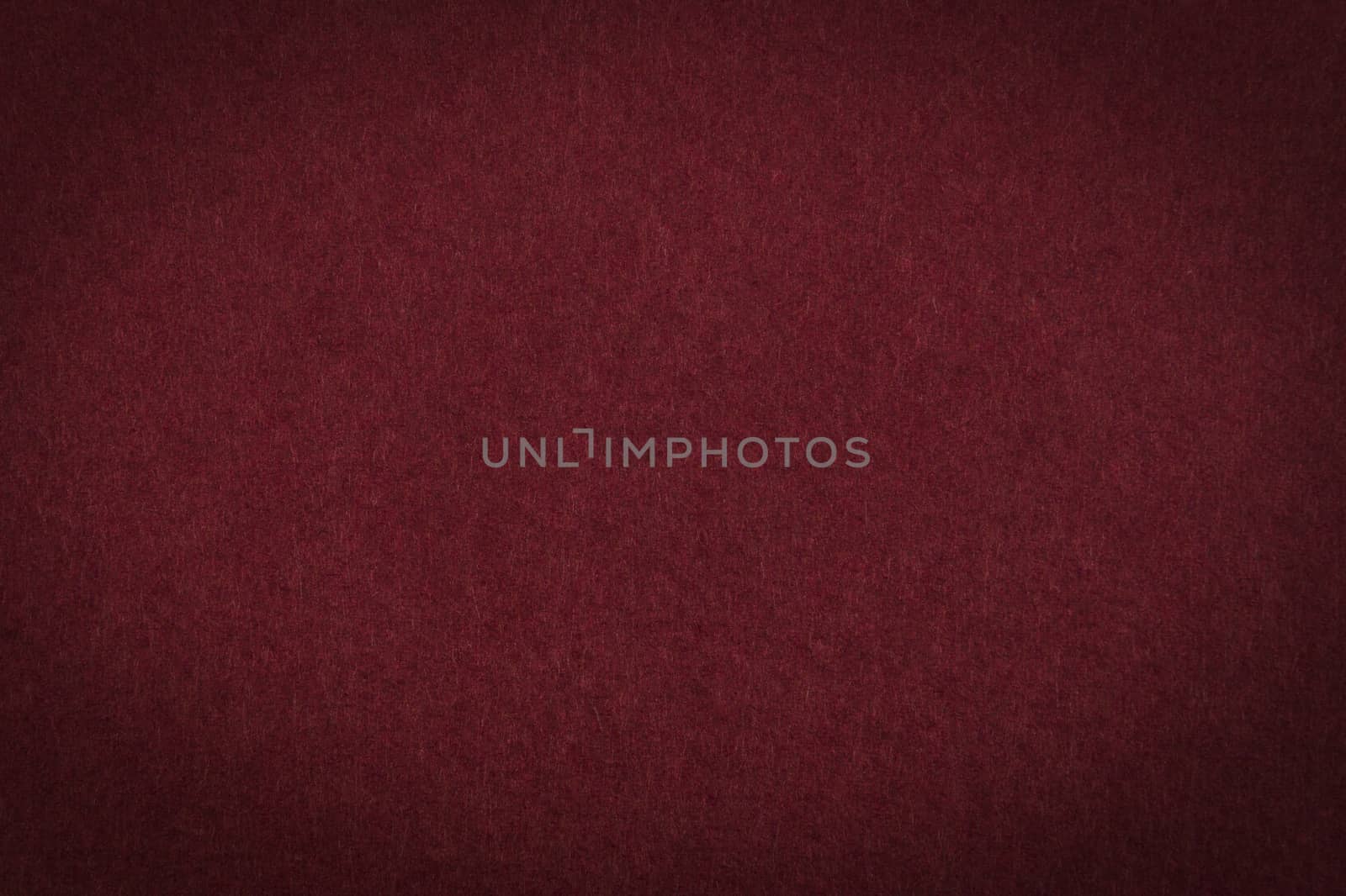 Maroon paper background or texture with vignette