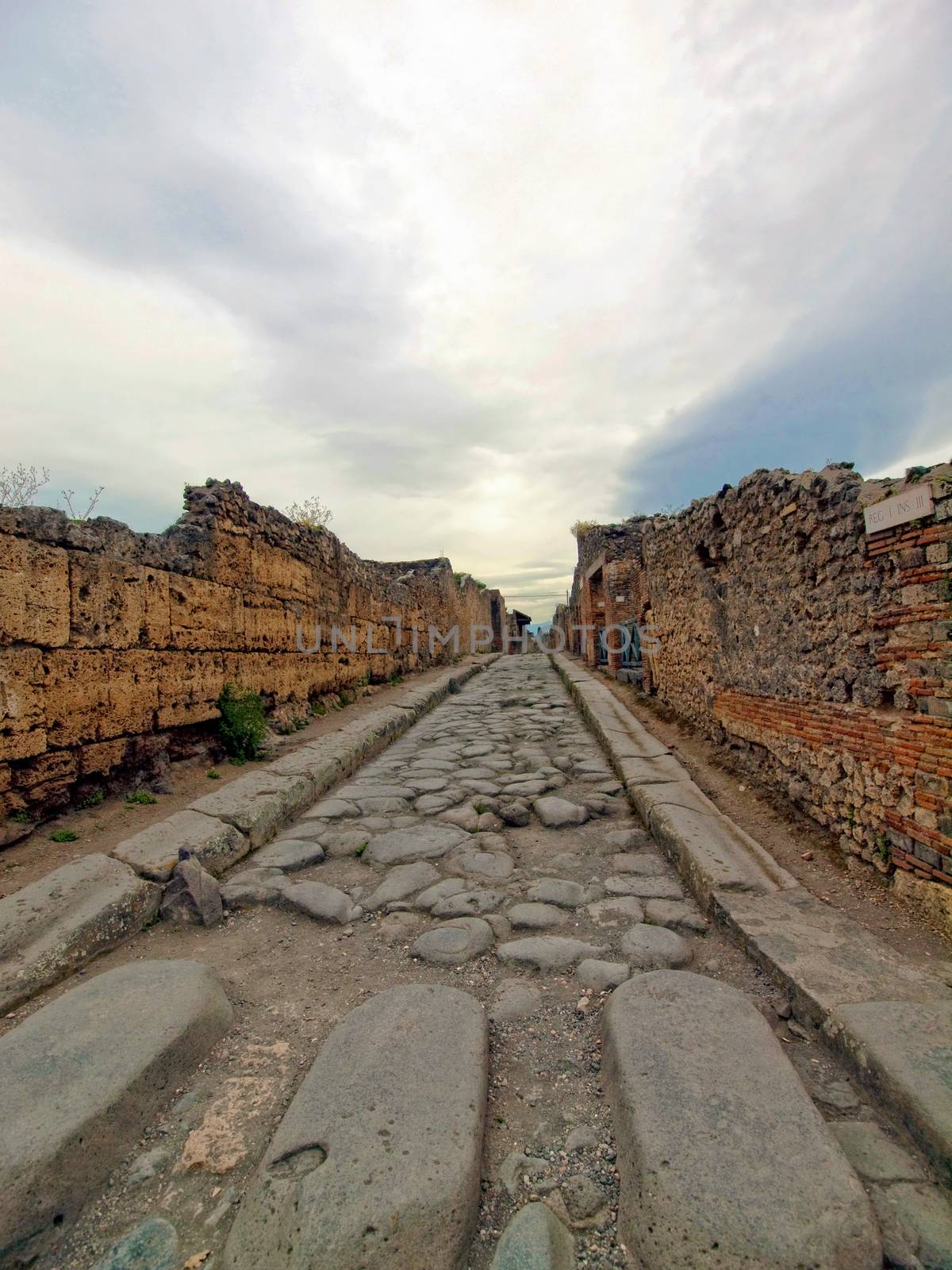 Street in Pompeii with a stone walkway for pedestrians, in Italy