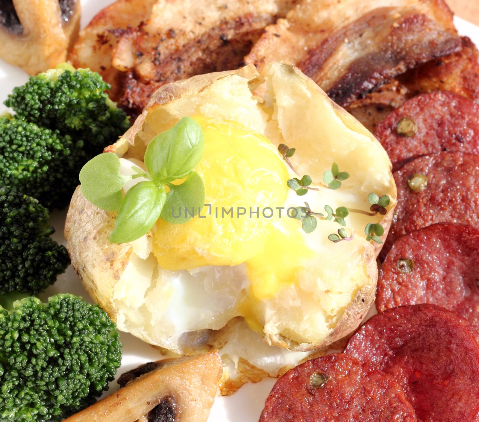 Fried egg with potatoes, served with vegetables, mushrooms, sausage and bacon 