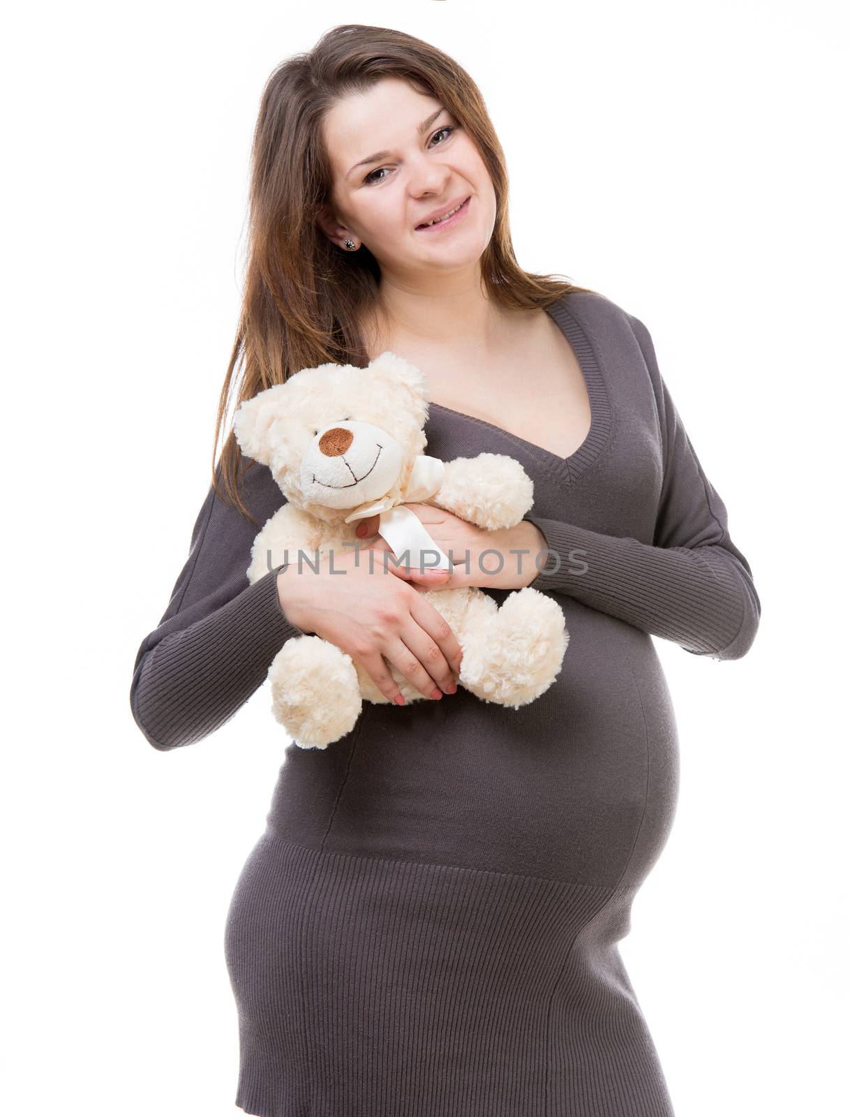 beautiful young pregnant woman in a gray dress with a teddy bear isolated on white background