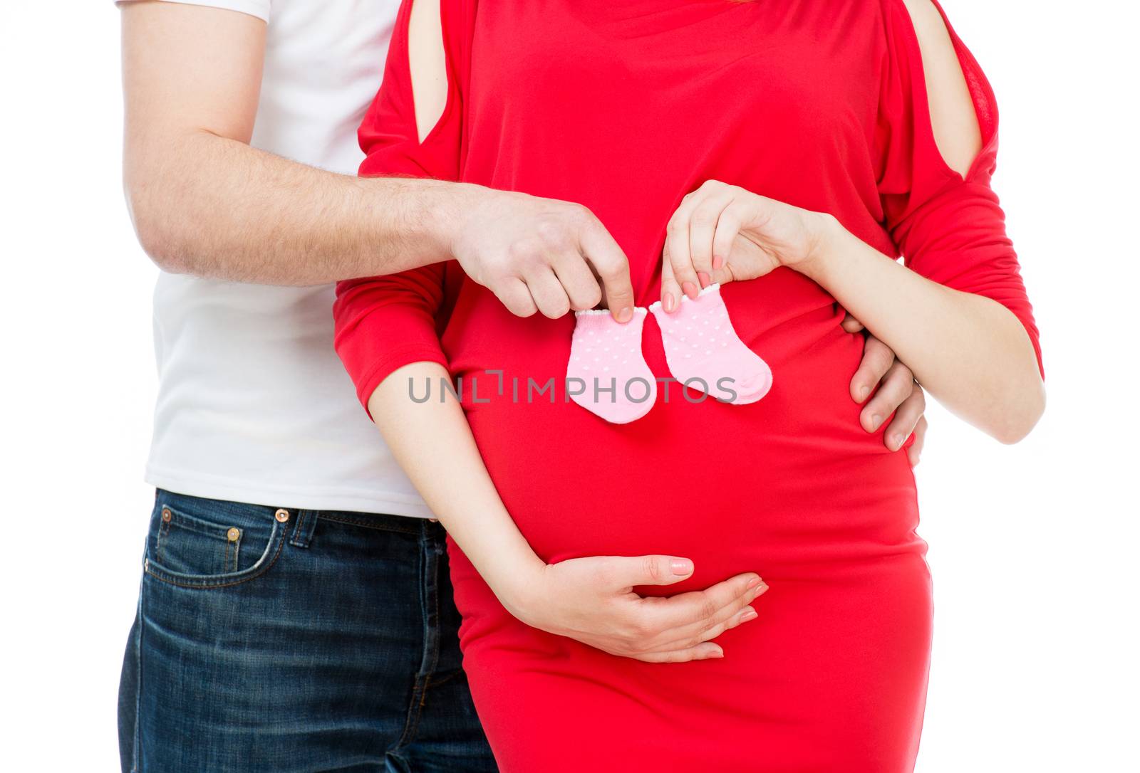 husband hugging his pregnant wife with socks for baby isolated on a white background