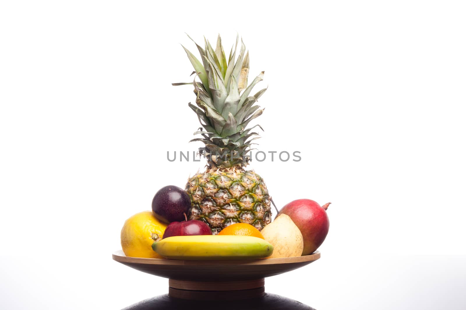 bunch of exotic fruits set up whit pineapple in the middle