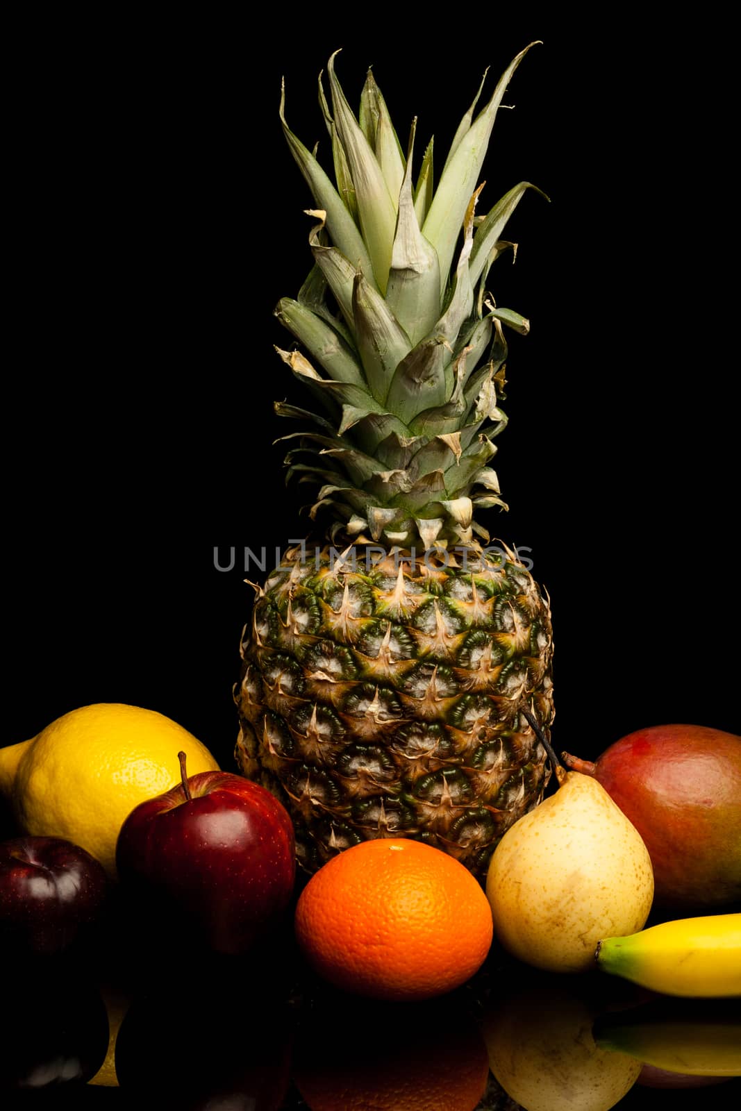 bunch of exotic fruits on black background with reflection