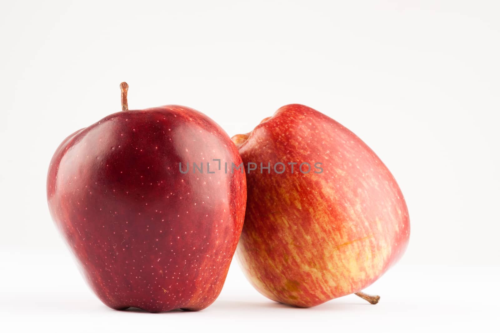 two red ripe fresh apples on white