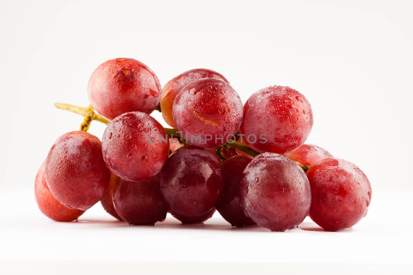 fresh rose grapes with waterdrops on white background