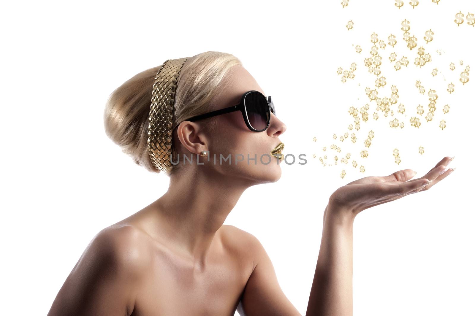 blond young woman in beauty shot looking on one side and blowing some golden star from her hand