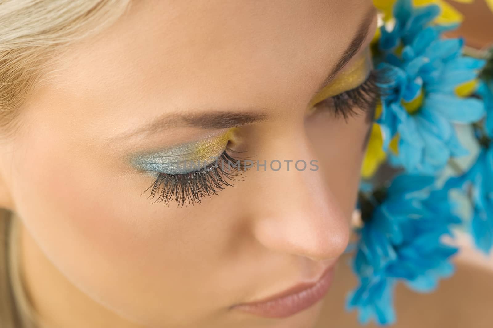 close-up of the girls eyes with colored make up and flowers