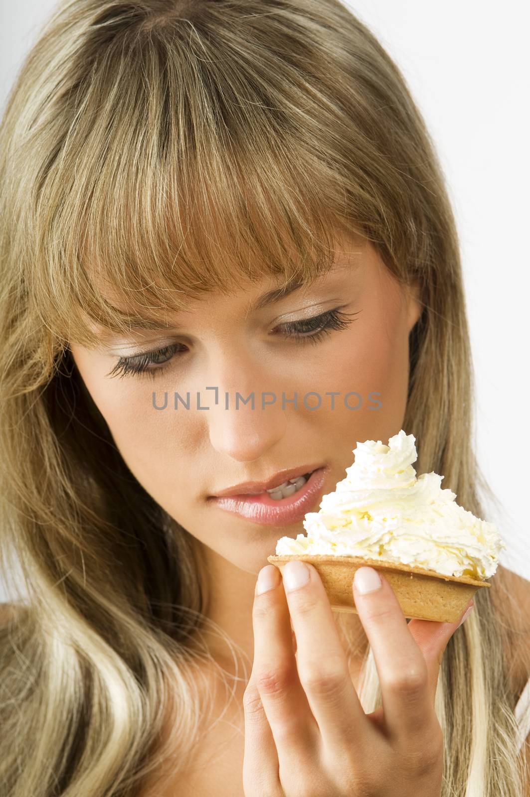 blond nice girl eating a dessert with a lot of cream