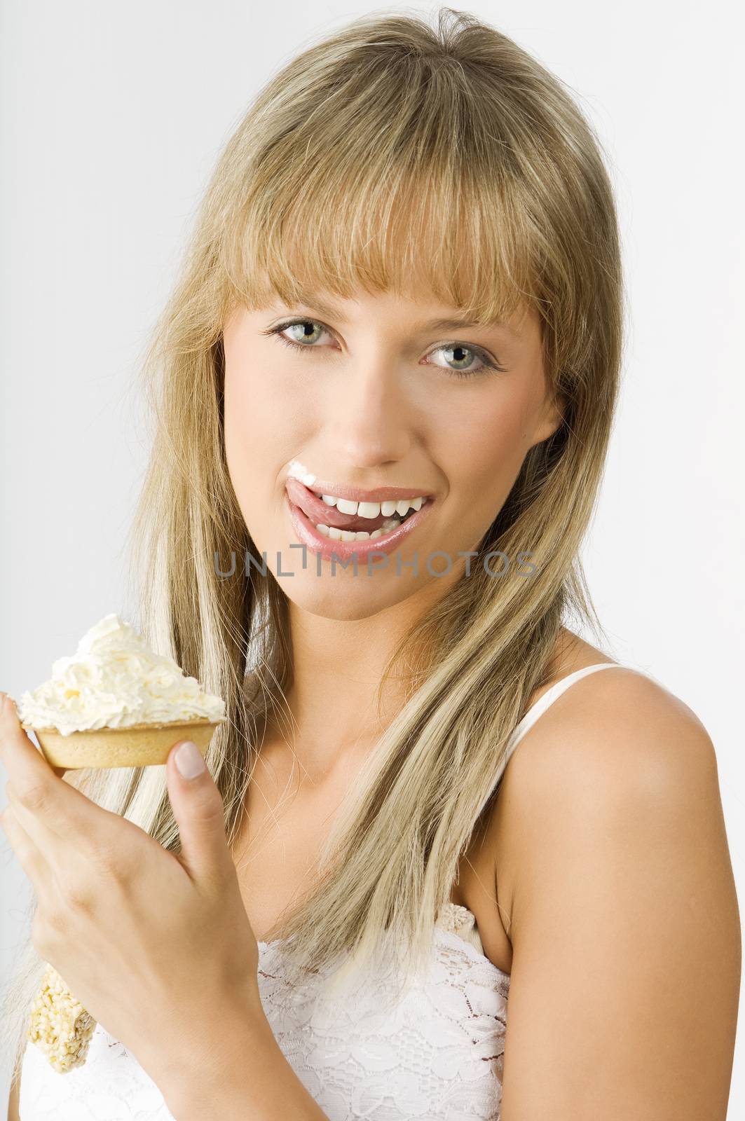 blond nice girl eating a dessert with a lot of cream