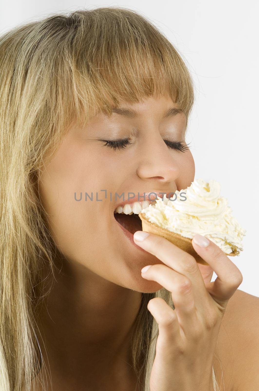 blond nice girl eating a dessert with a lot of cream