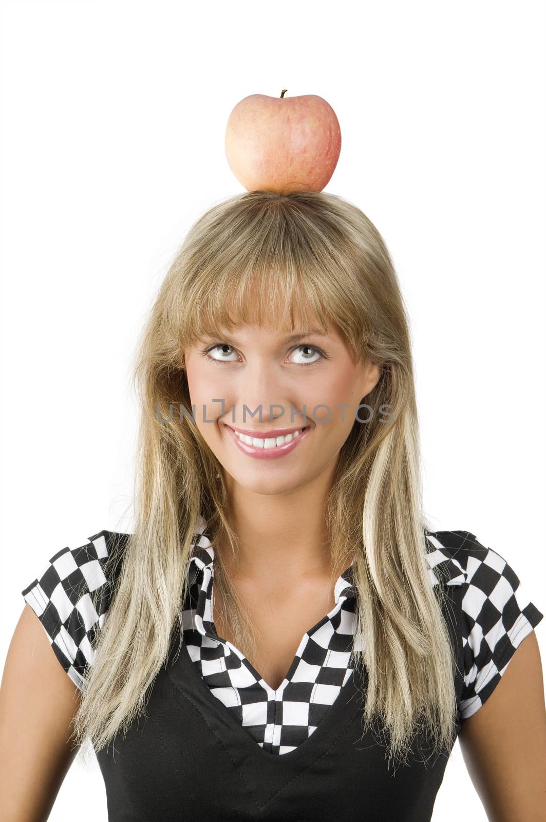 cute young girl with a red apple on her head making face