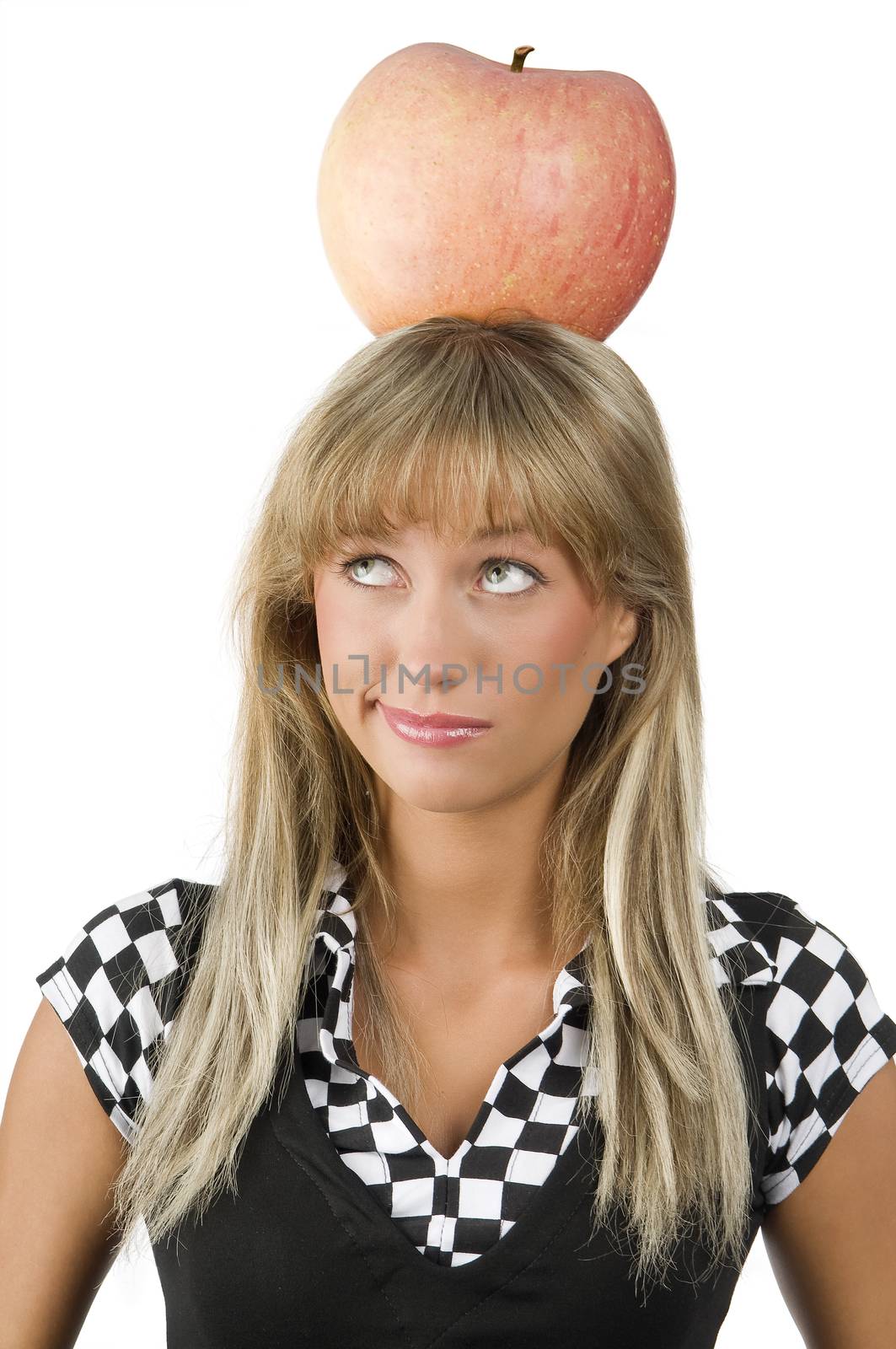 cute young girl with a big red apple on her head looking up with the eyes