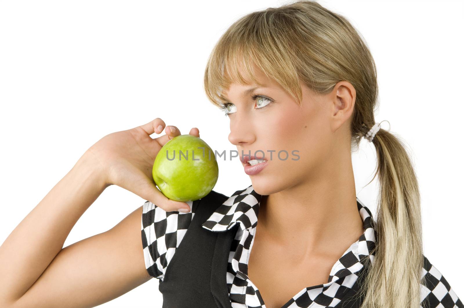 cute blond girl with a light green eyes looking away and keeping a green apple