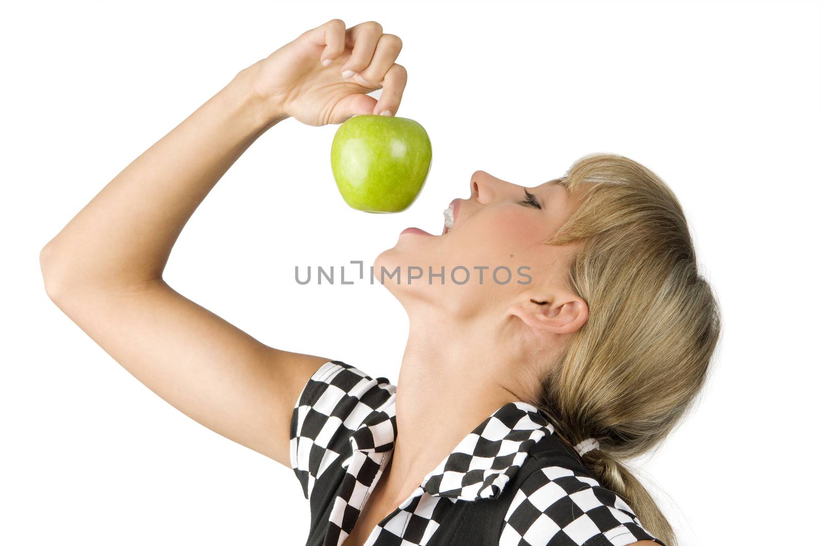 nice young girl trying to bite a green apple