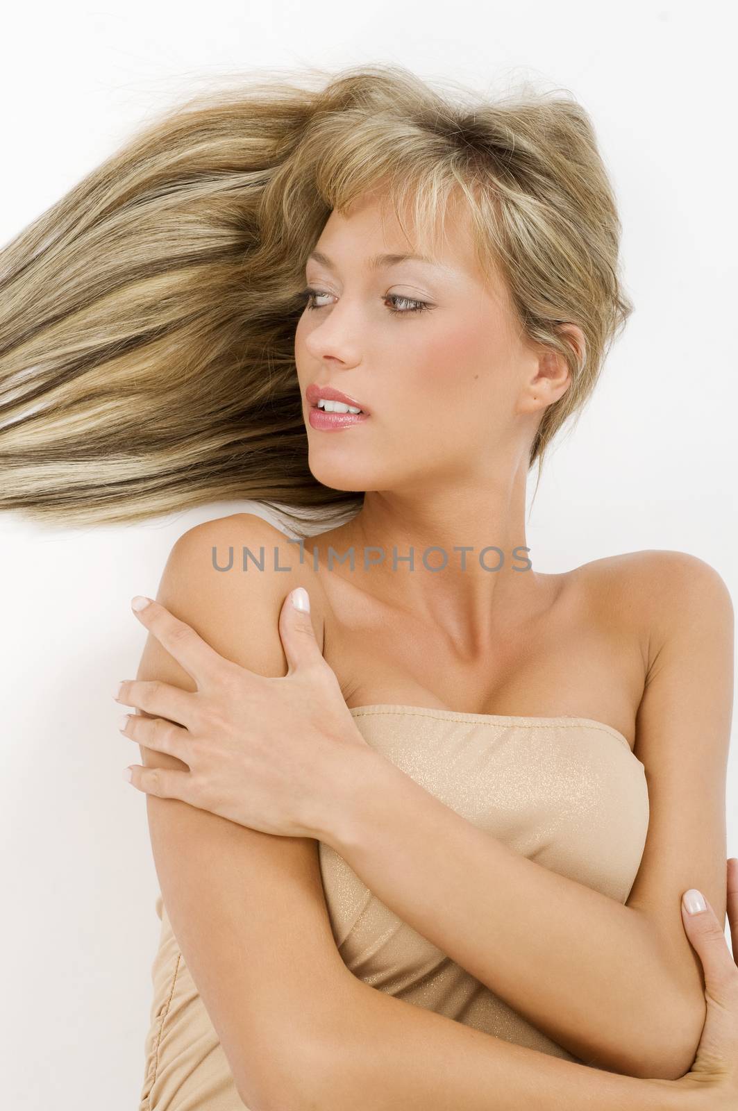 portrait of a cute blond girl laying down on the floor with hair on one side