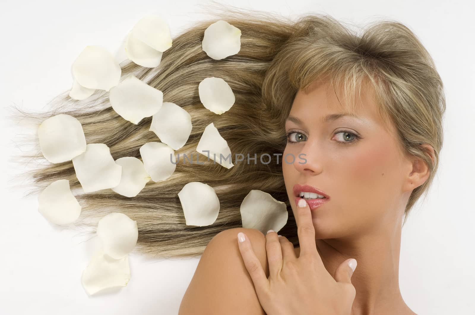 pretty close up of a blond girl laying down with roses white petals on hair