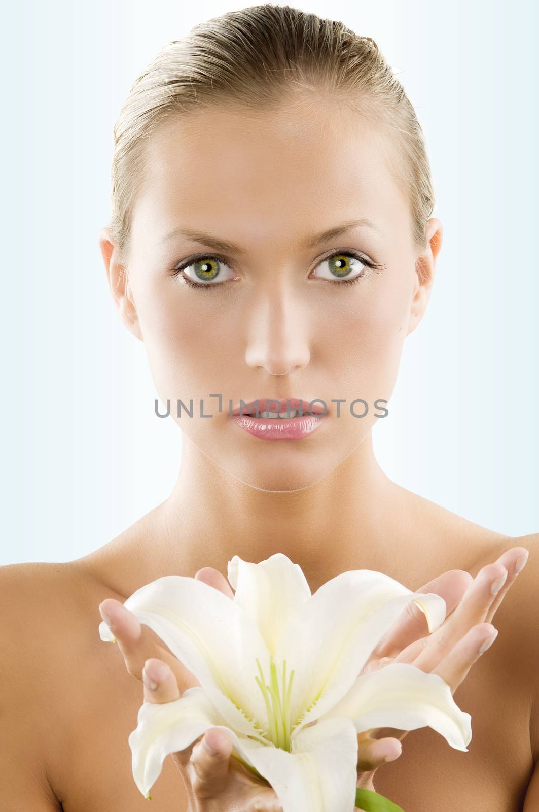 fresh portrait of a young and beautiful woman with a white lily and wet hair