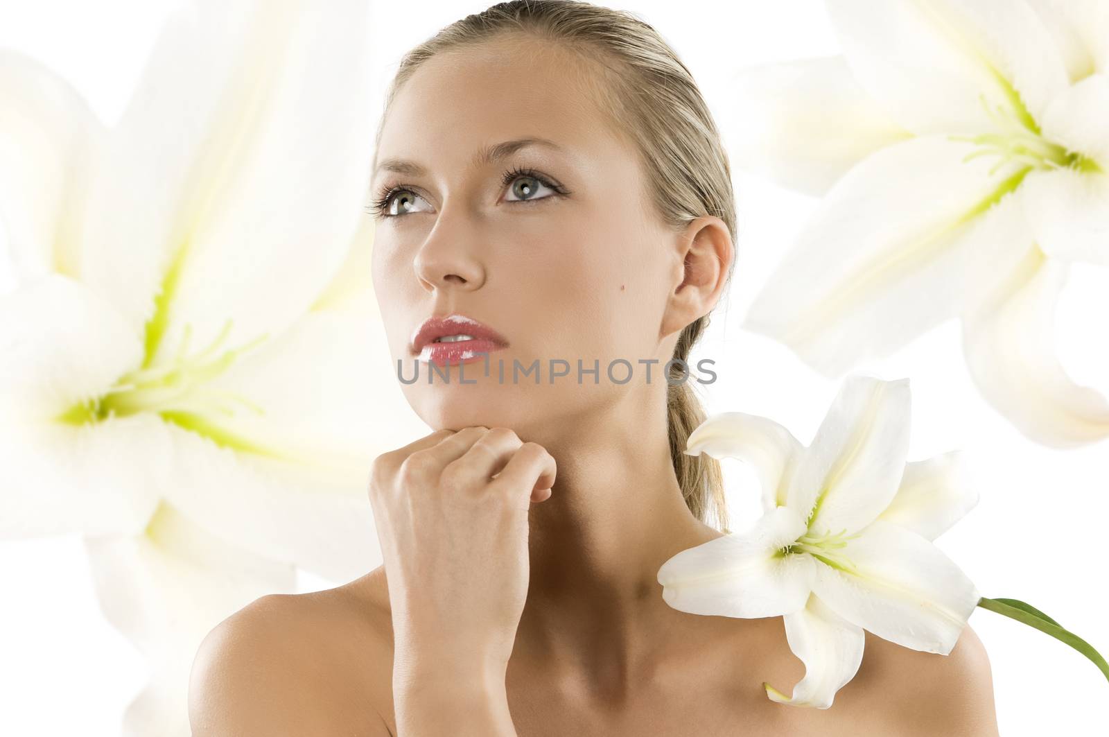 young woman with white lily on her shoulder looking up with eyes