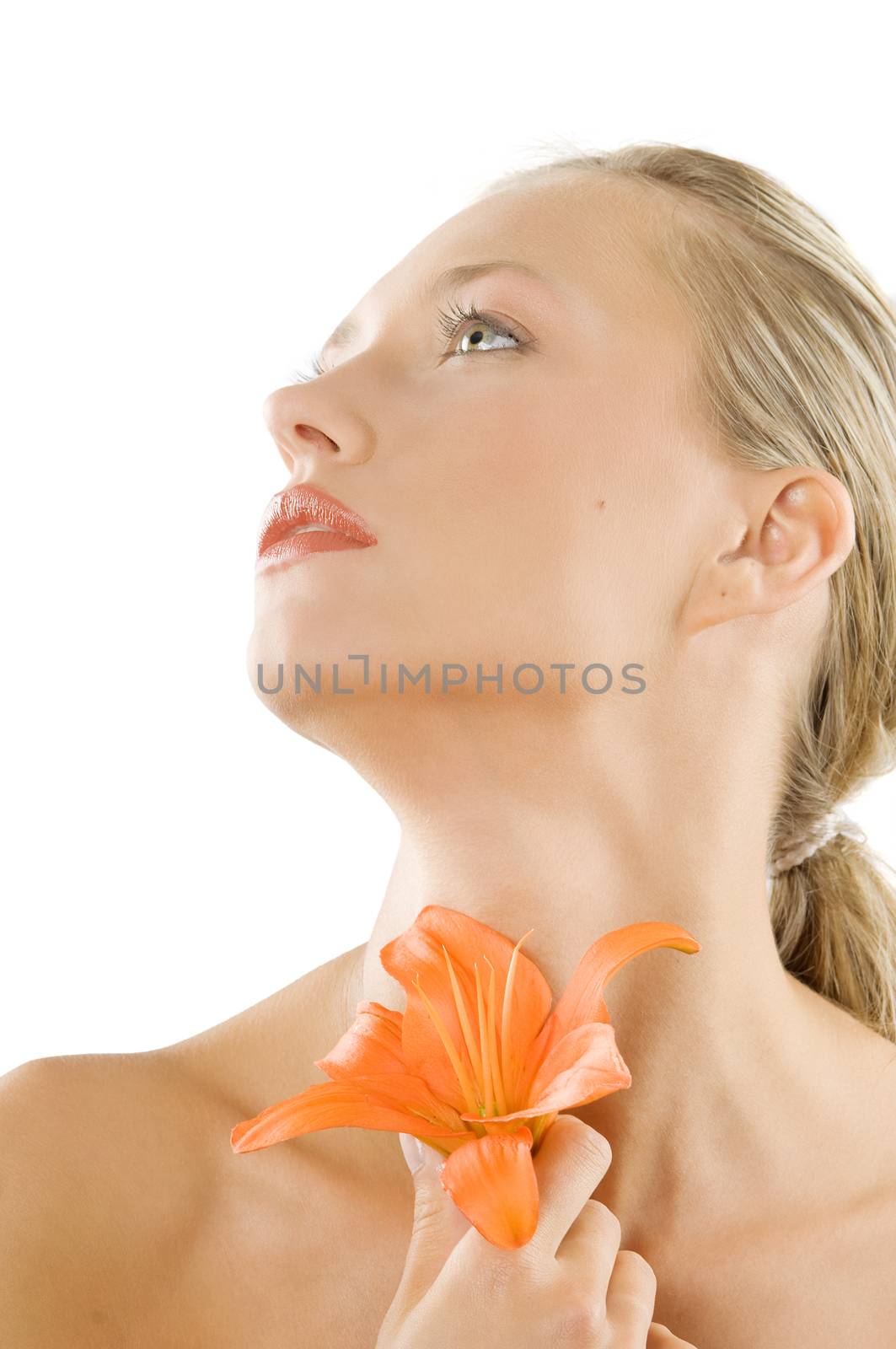 pretty blond girl with fair eyes looking up with a flower in hand