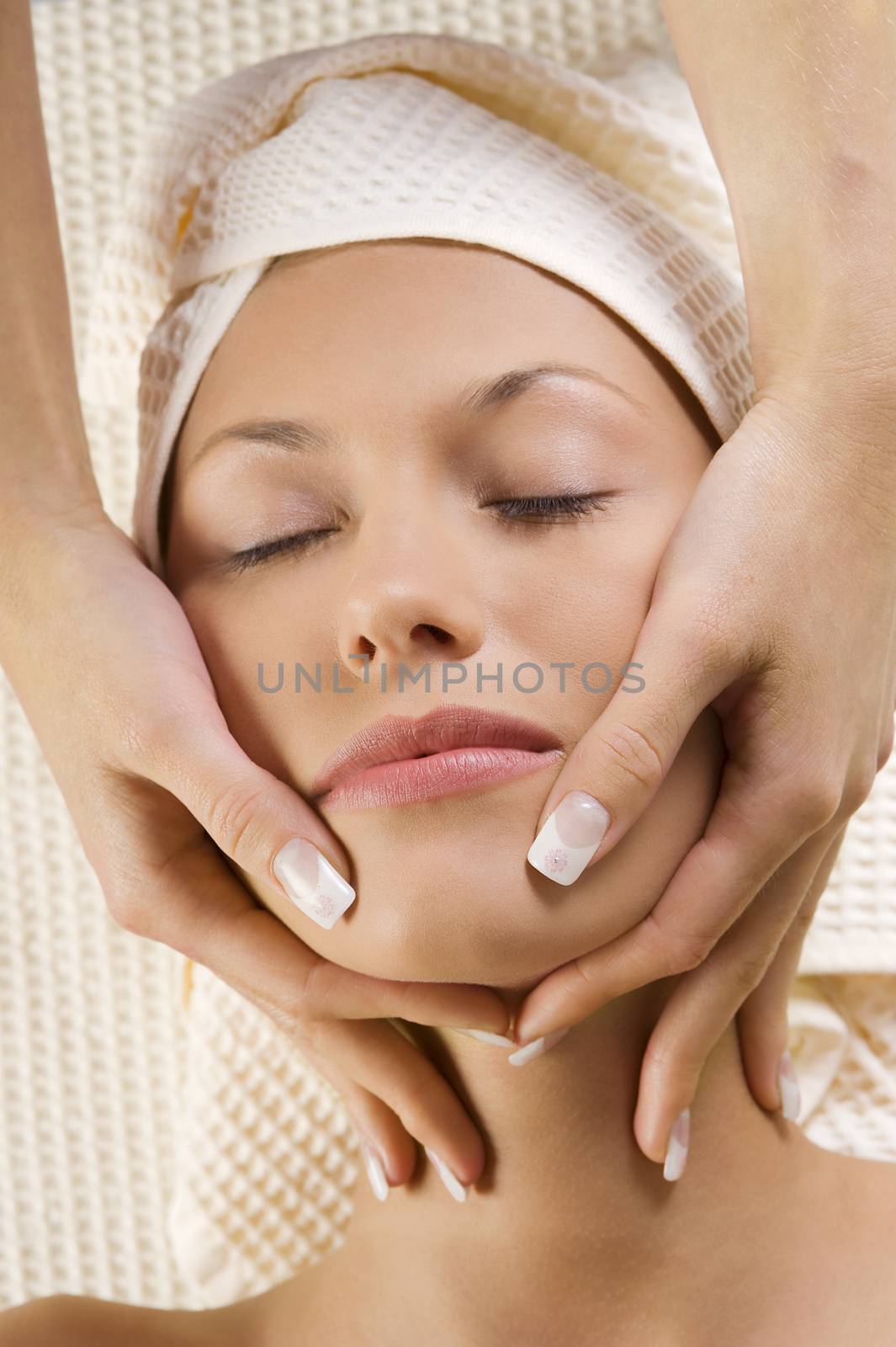 close up of young cute girl getting a massage on her face