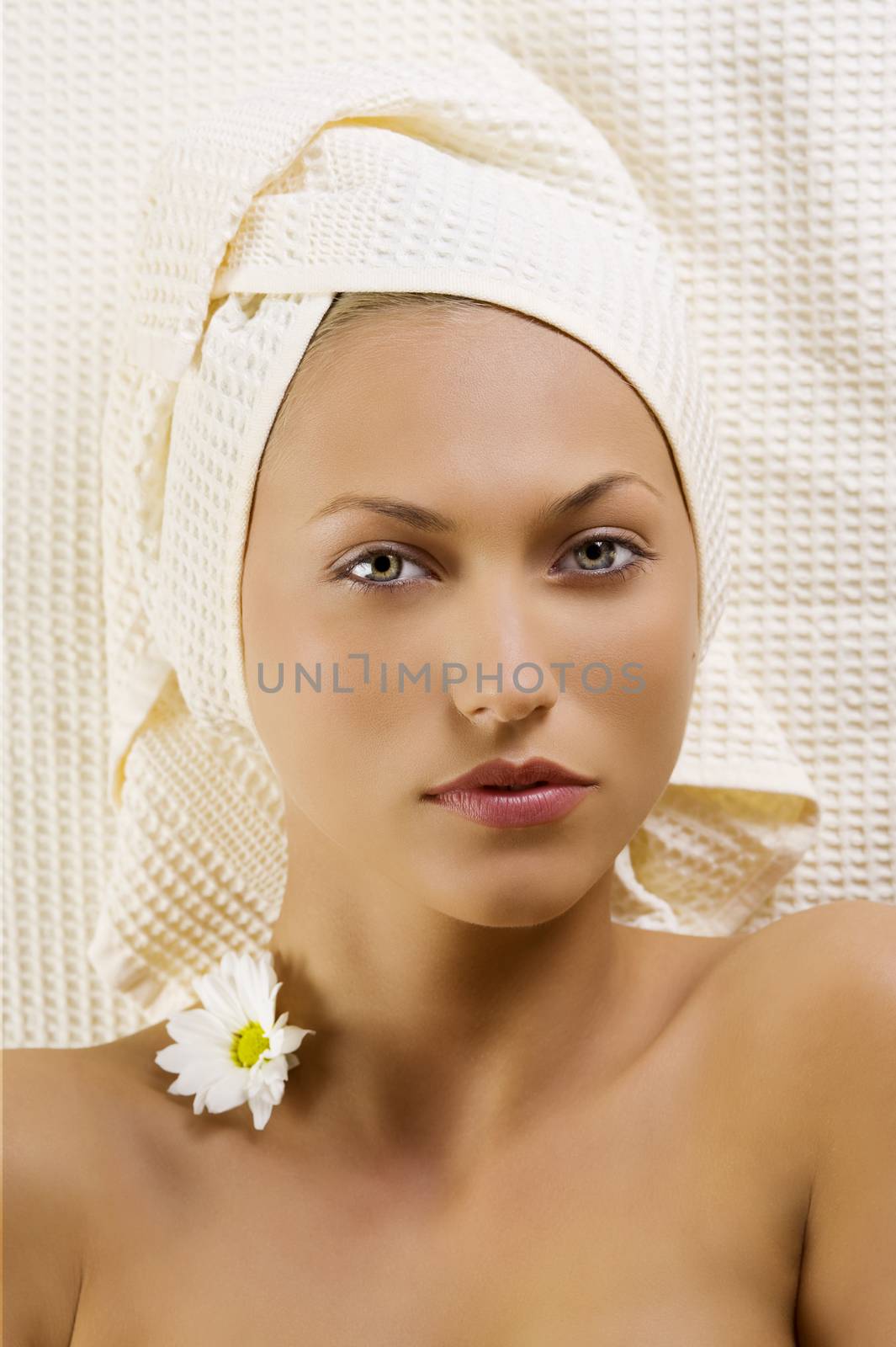 nice portrait of young and pretty woman with bath towel and flowers on neck