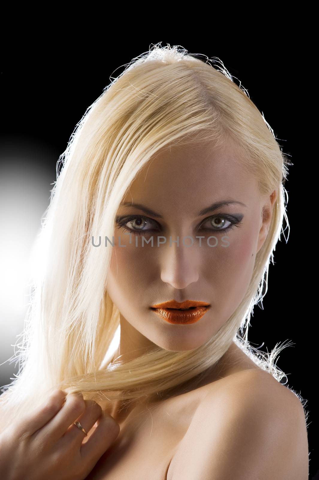 sexy blond girl in a close up portrait on black and strong back light