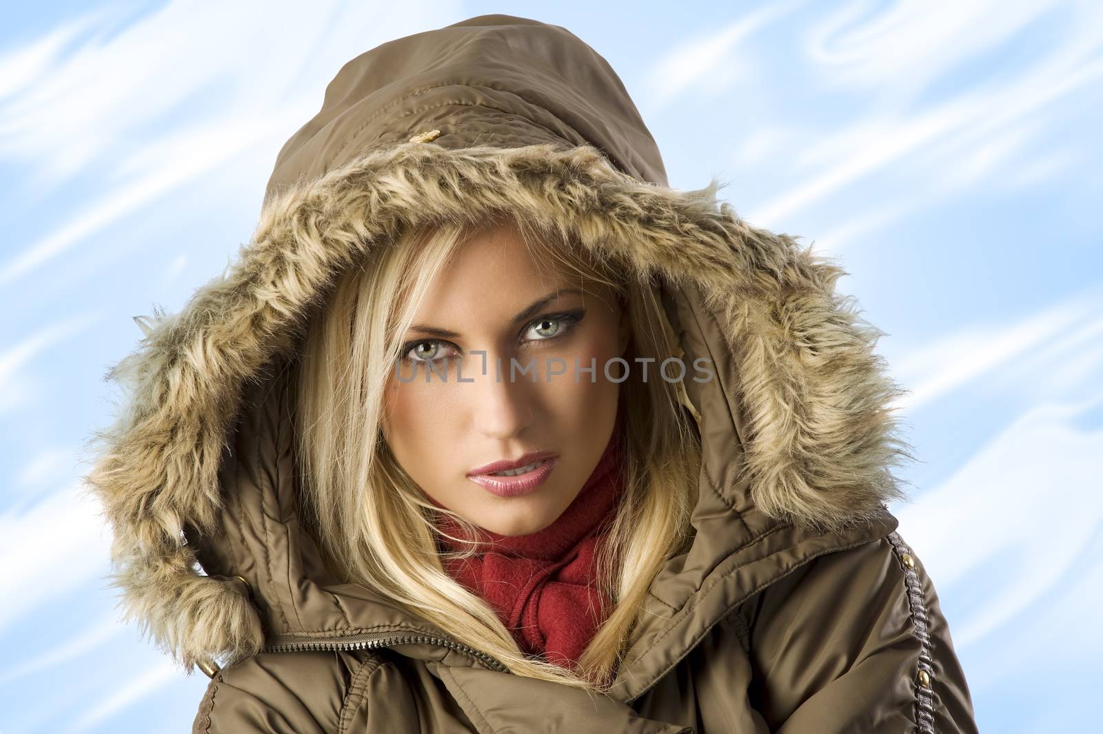 fashion shot portrait of a young blond woman in winter jacket with hood and fur