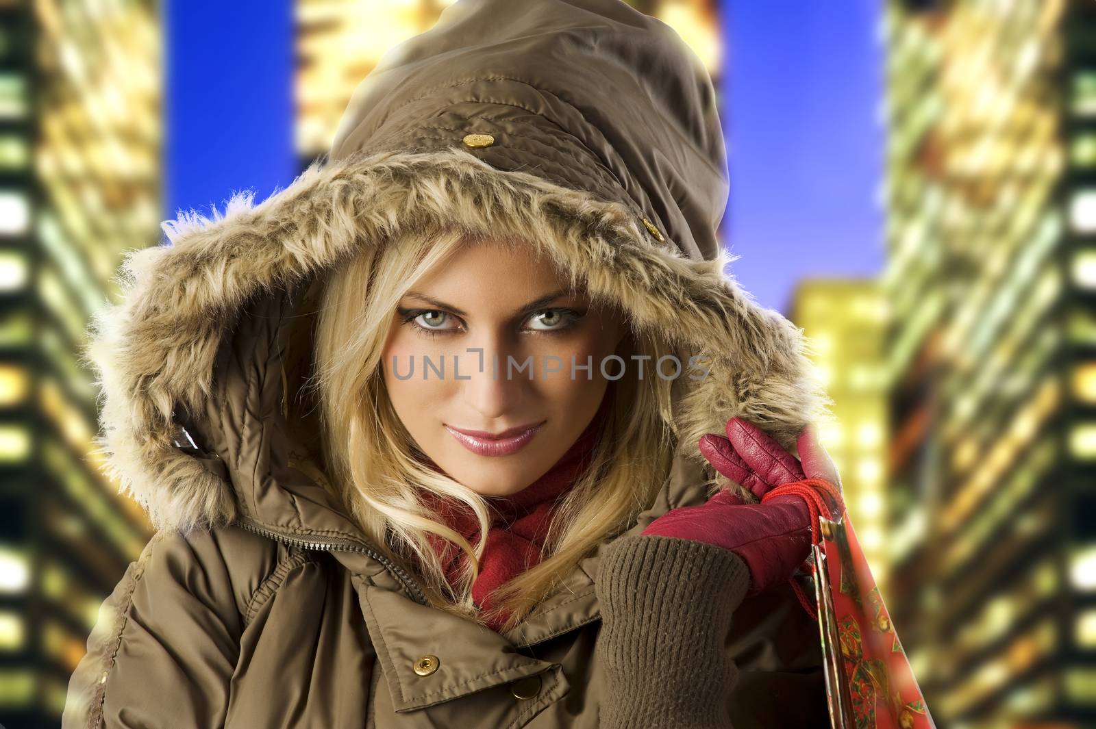 close up portrait of blond young woman in winter jacket covering head with hood