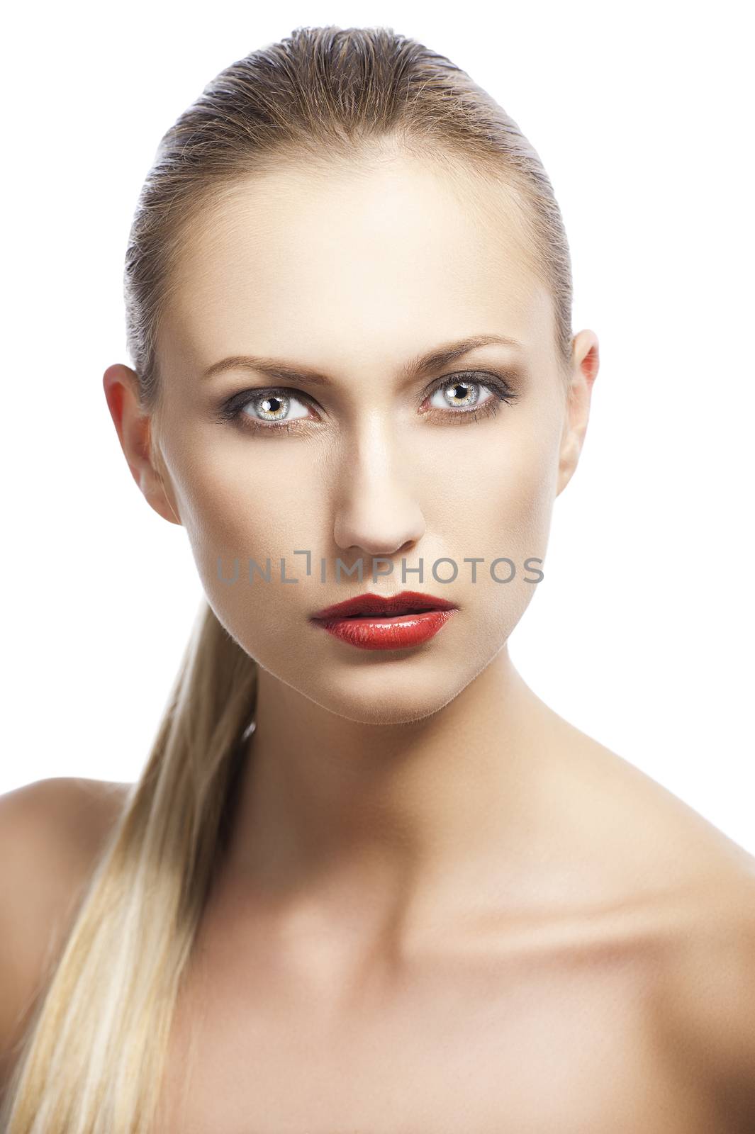 blond pretty woman in a beauty portrait with wet hair and a straight tail over shoulder. She looks in to the lens and she has the tail over the right shoulder.