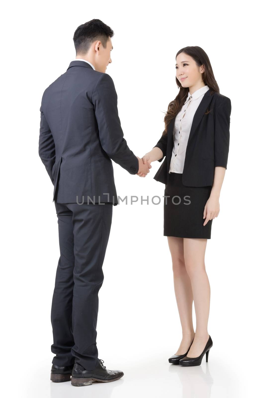 Business woman and man shake hands, full length portrait isolated on white background.