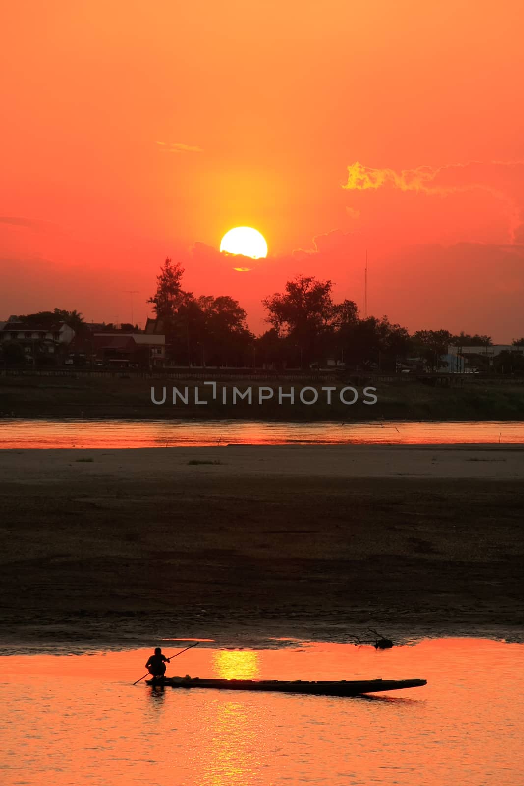 Silhouetted boat on Mekong river at sunset, Vientiane, Laos, Southeast Asia