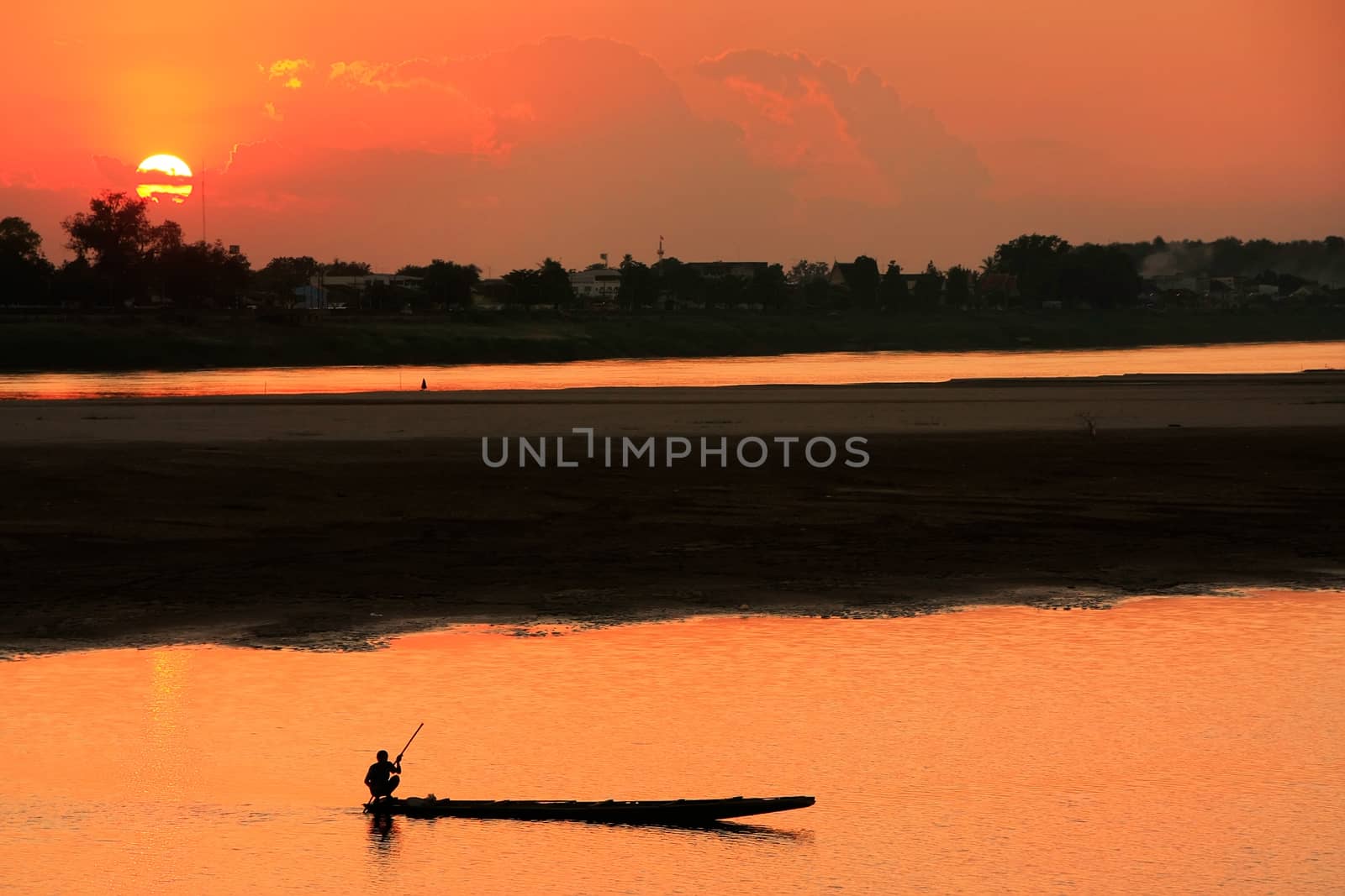 Silhouetted boat on Mekong river at sunset, Vientiane, Laos, Southeast Asia