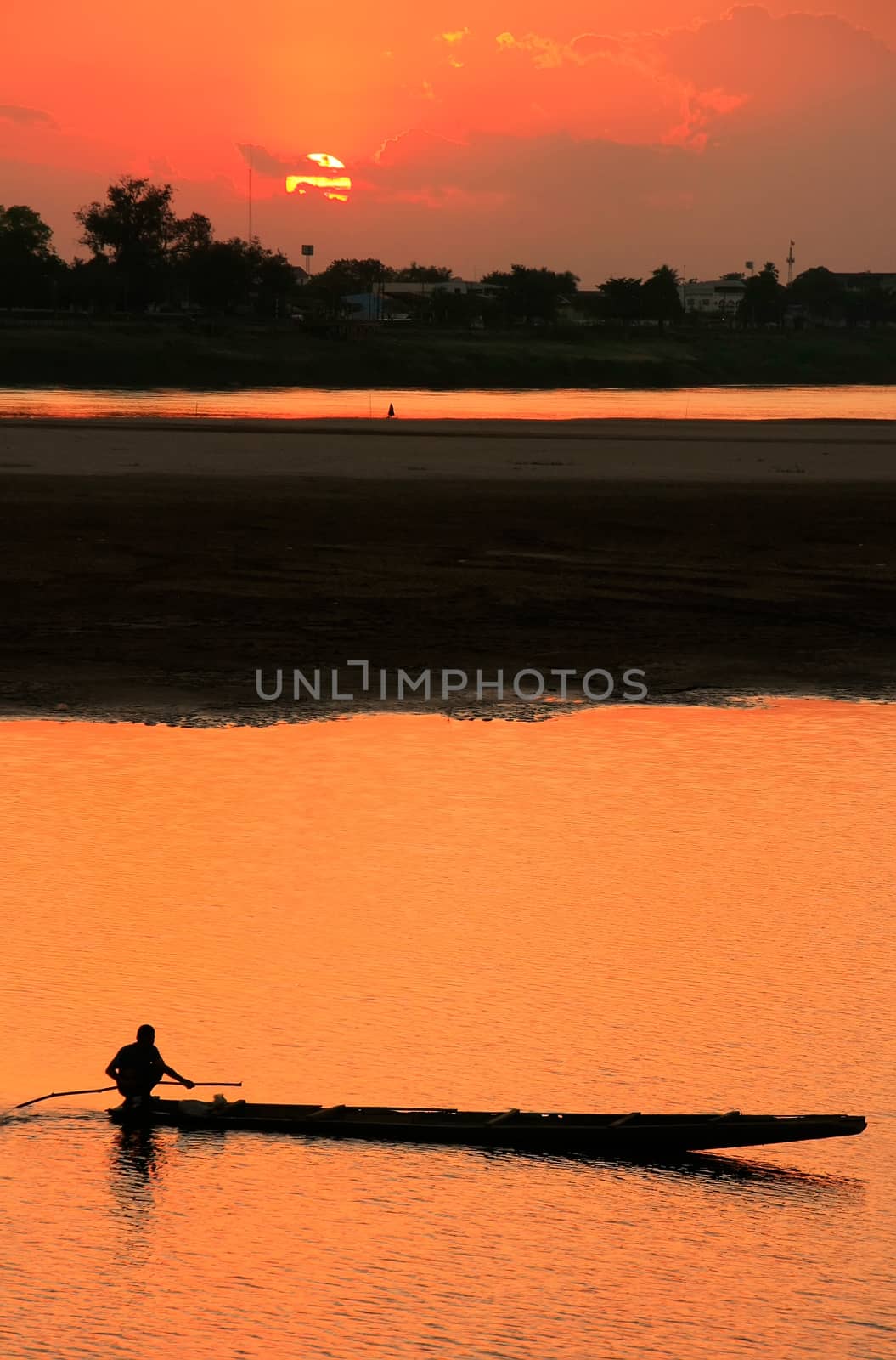 Silhouetted boat on Mekong river at sunset, Vientiane, Laos, Southeast Asia
