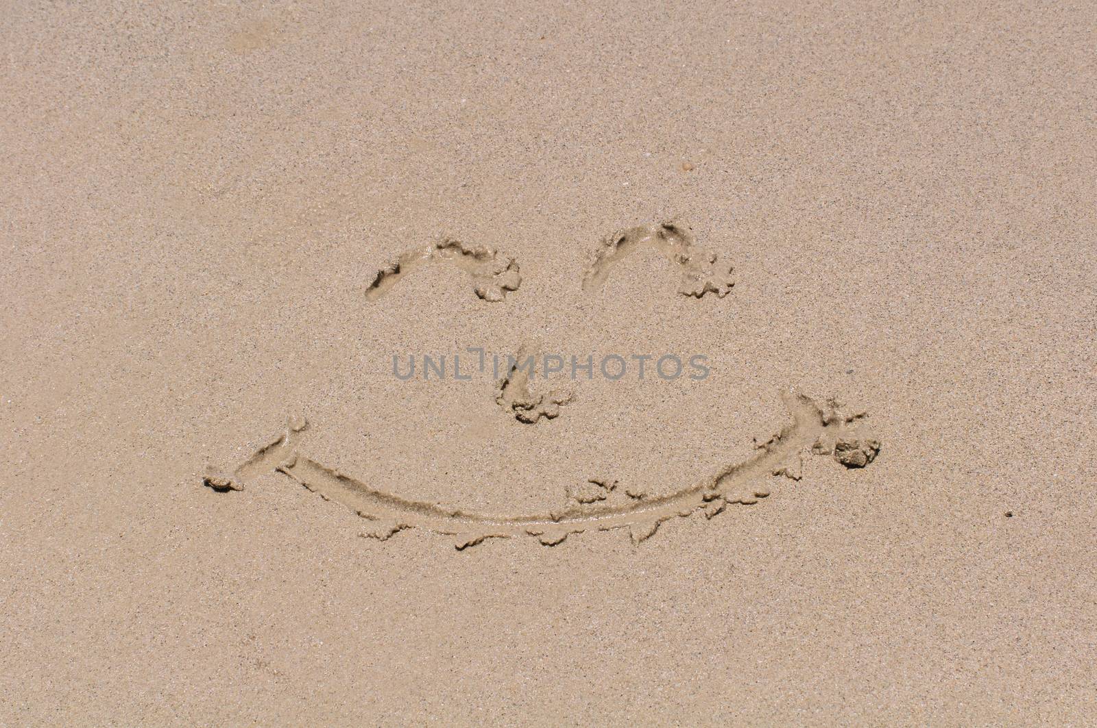 Drawing a smiley face on the sand.