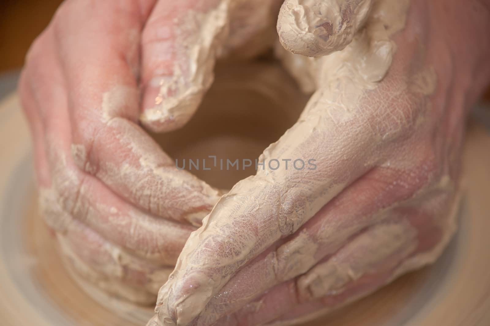 hands of a potter, creating an earthen jar on the circle