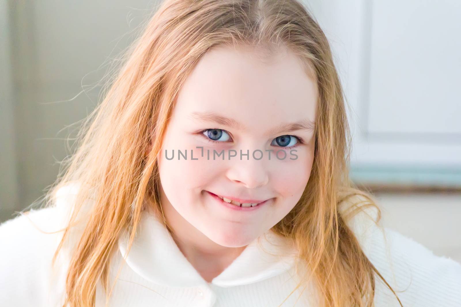 Portrait of cute girl with blond hair in white