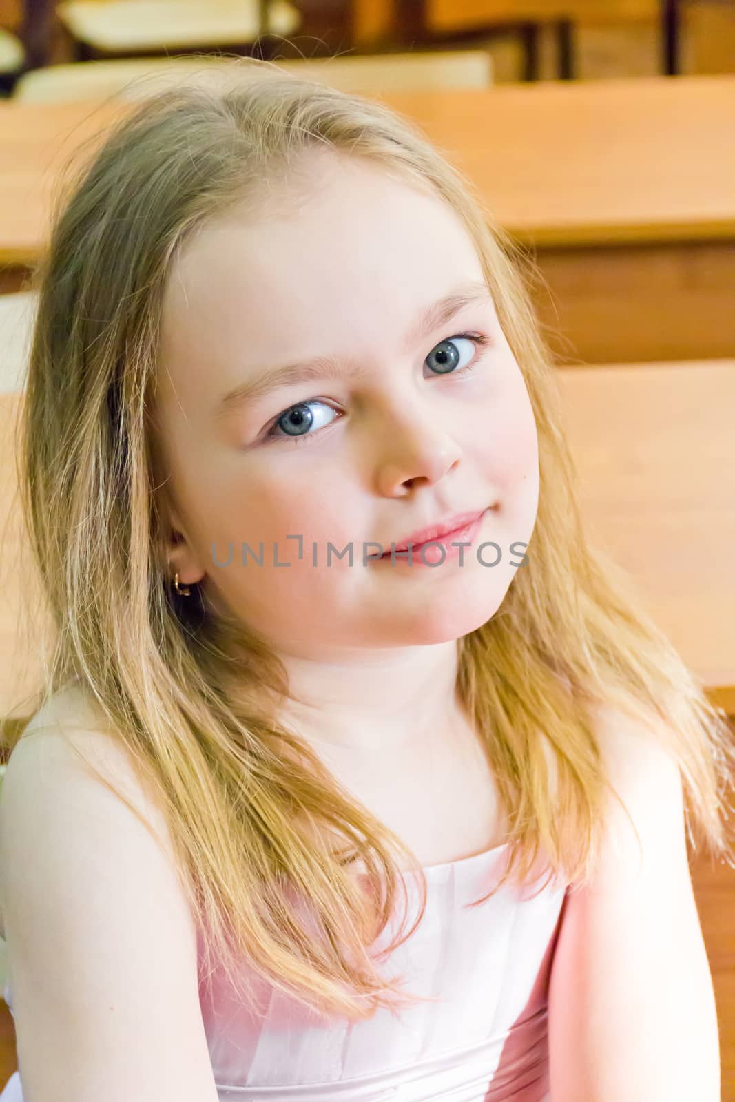 Portrait of cute younger schoolgirl with blond hair