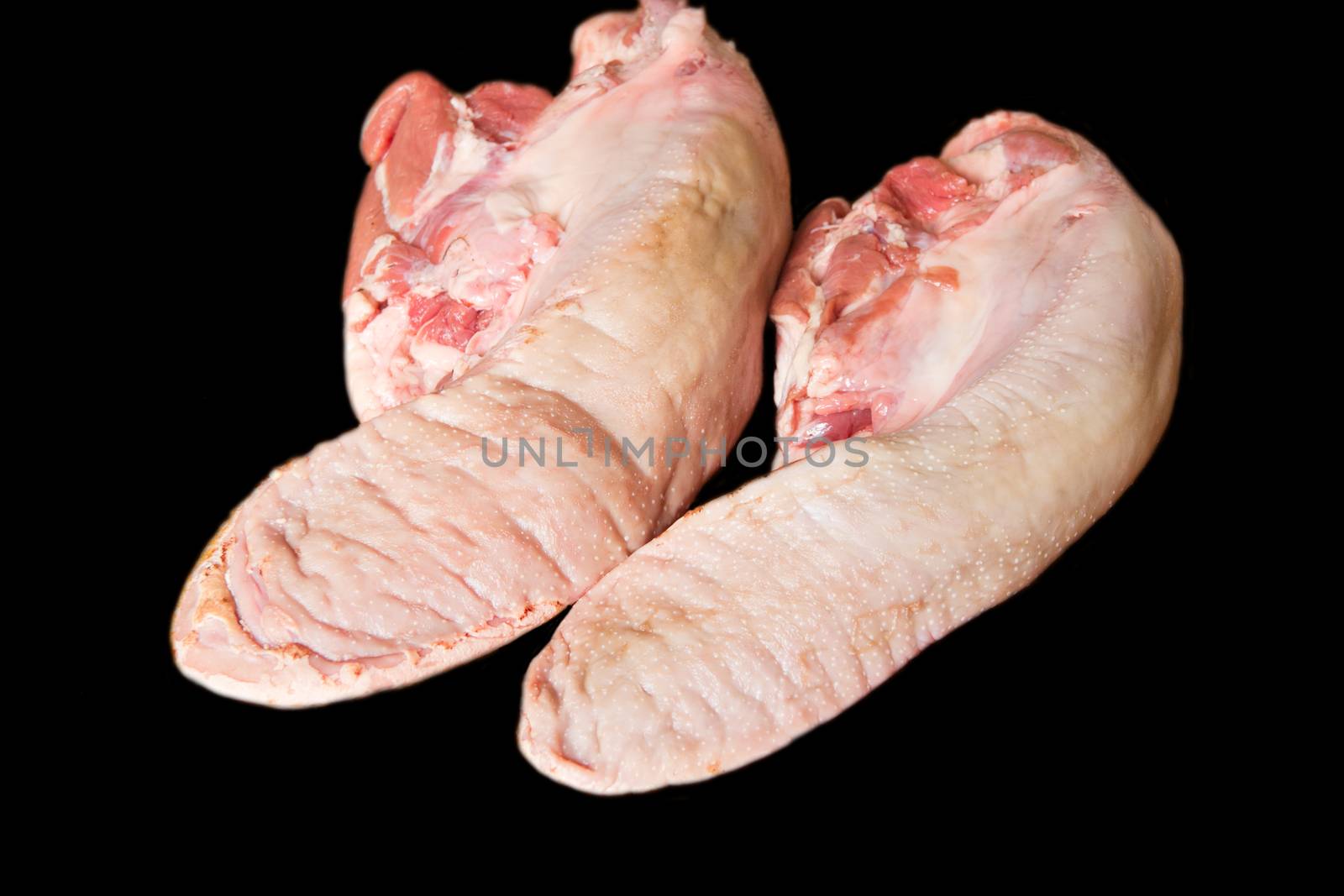 Photo of raw pork tongue on black background