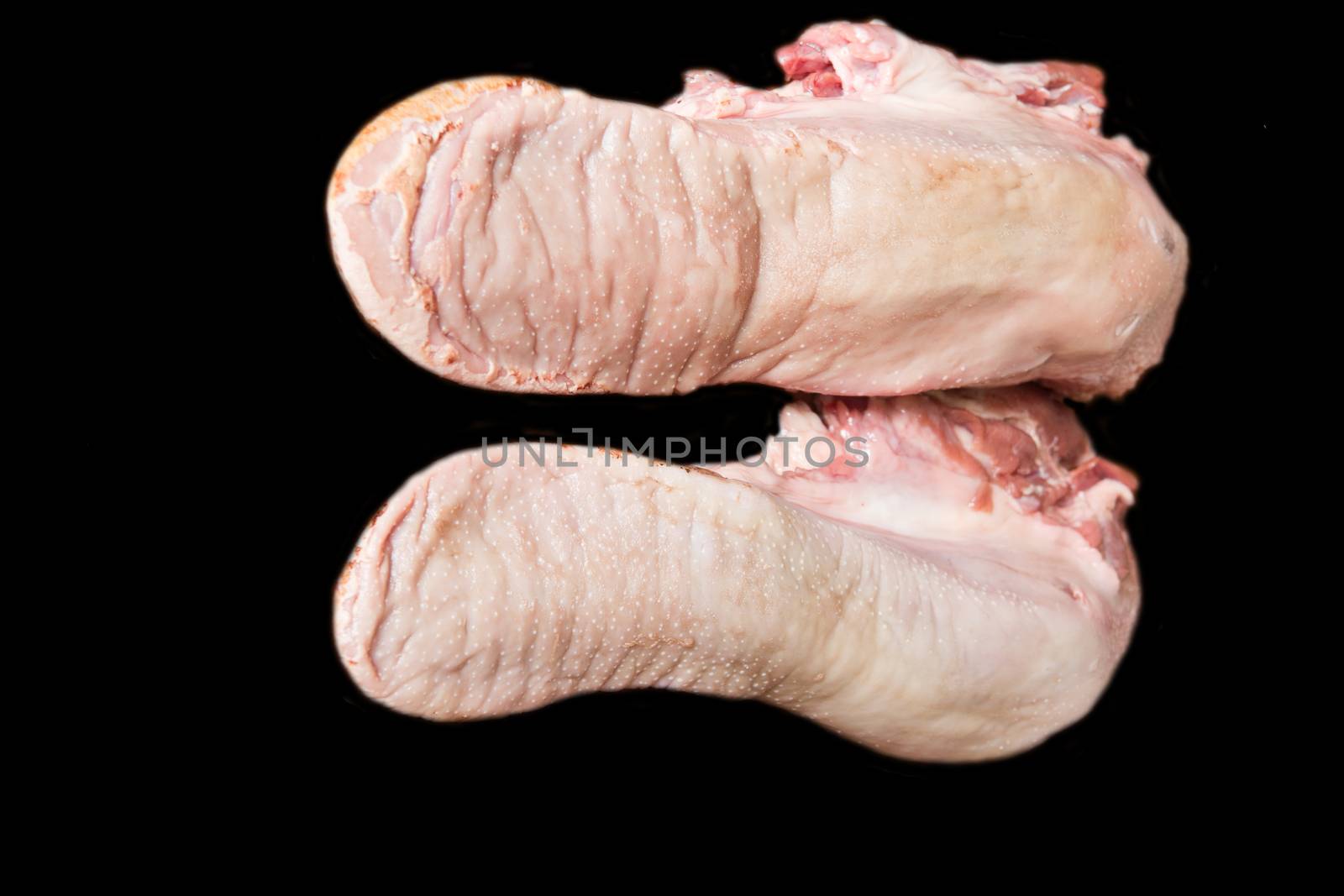 Photo of raw pork tongue on black background