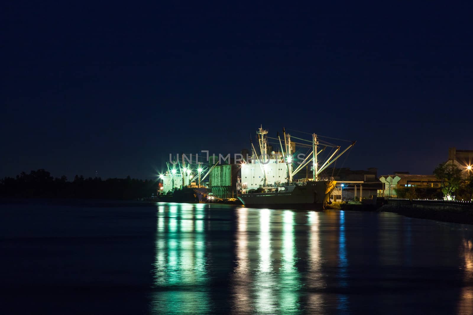 Shipping port at night. Cargo ship to dock at night.