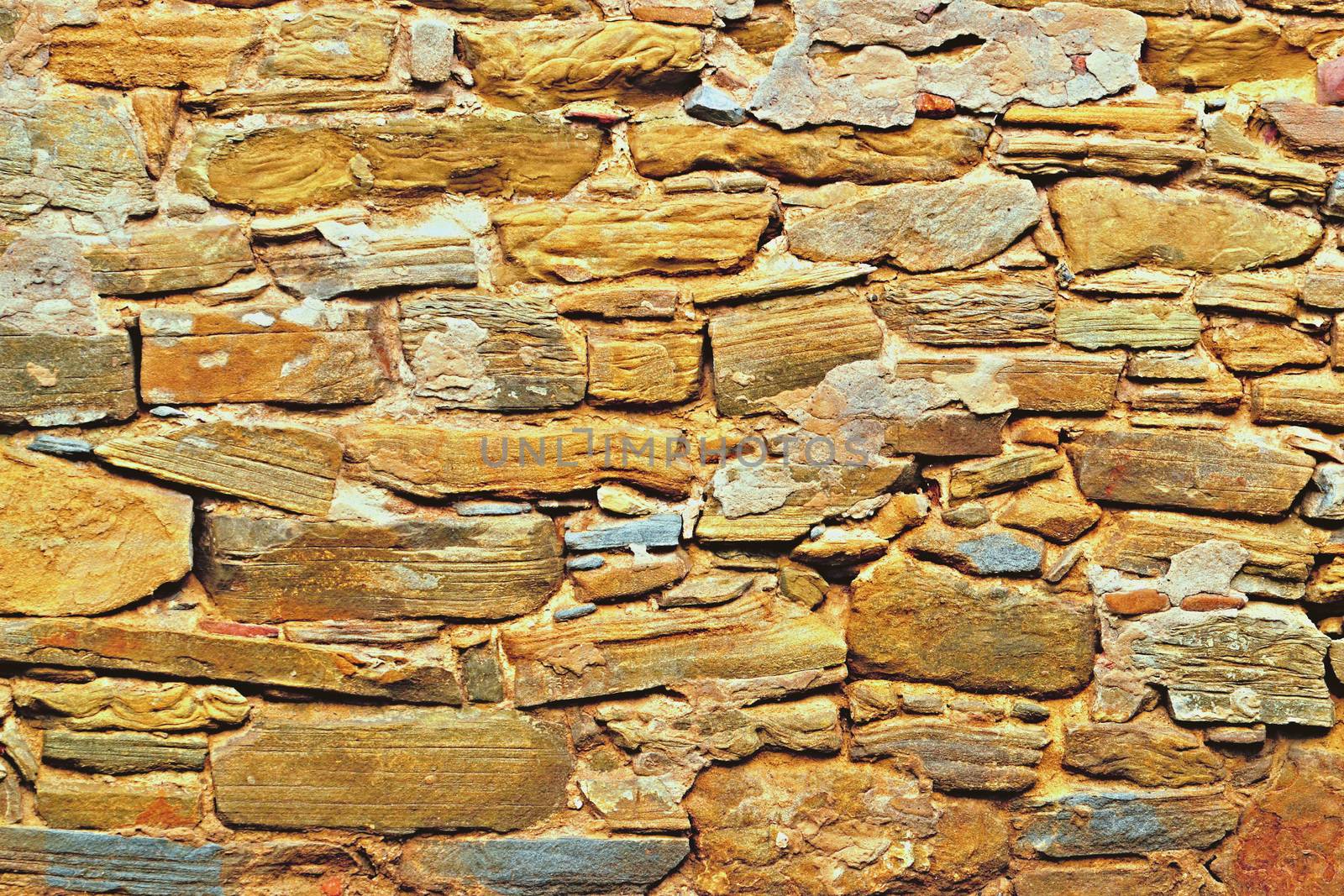 Old stone wall with sandstone rocks ocher color