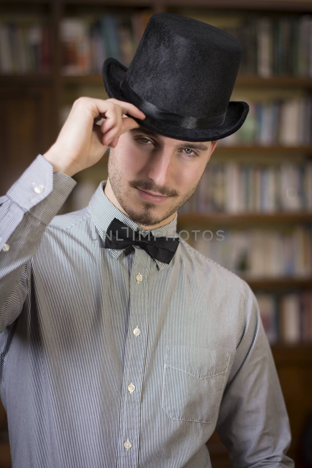 Elegant young man wearing top hat and bow tie by artofphoto