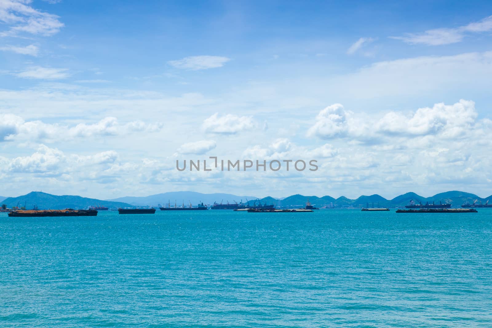 Cargo ship moored in the sea. Waiting for the check from the docks along the shore.