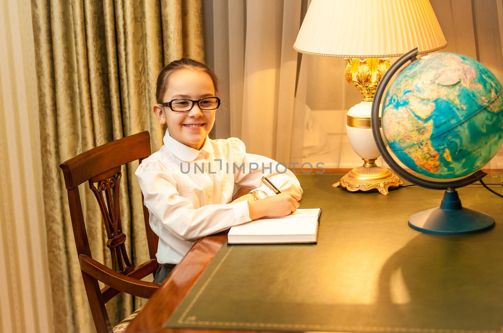 Smiling girl doing homework at classic desk