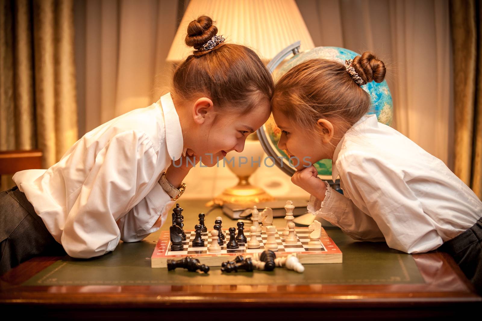 Little sister playing chess and looking eye to eye by Kryzhov