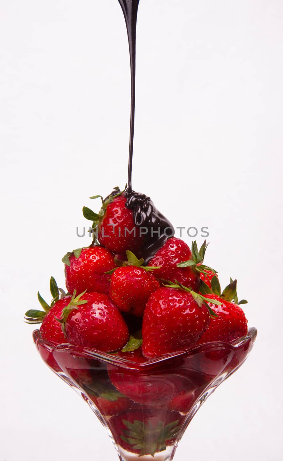 Chocolate sauce hits the berries in a glass parfait container