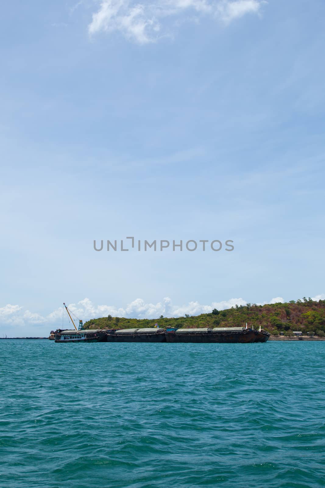 Large cargo ship. Moored at sea. Island near the docks.
